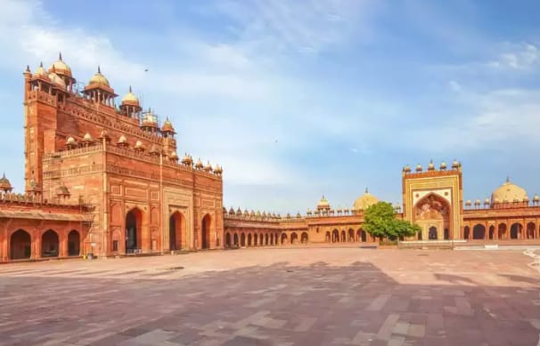 Expert guide explaining the Indo-Islamic architecture at Fatehpur Sikri on a Golden Triangle with Aligarh heritage tour