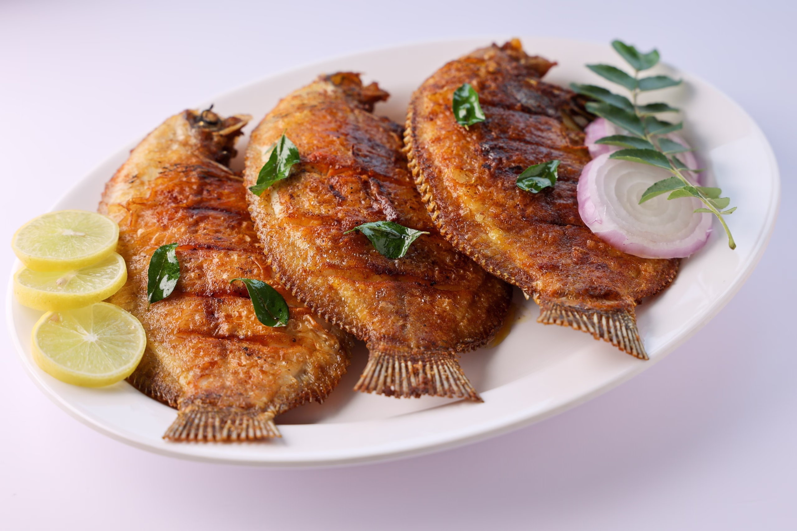 Fresh Karimeen Pollichathu, a certified Halal seafood dish at a Marari Beach restaurant