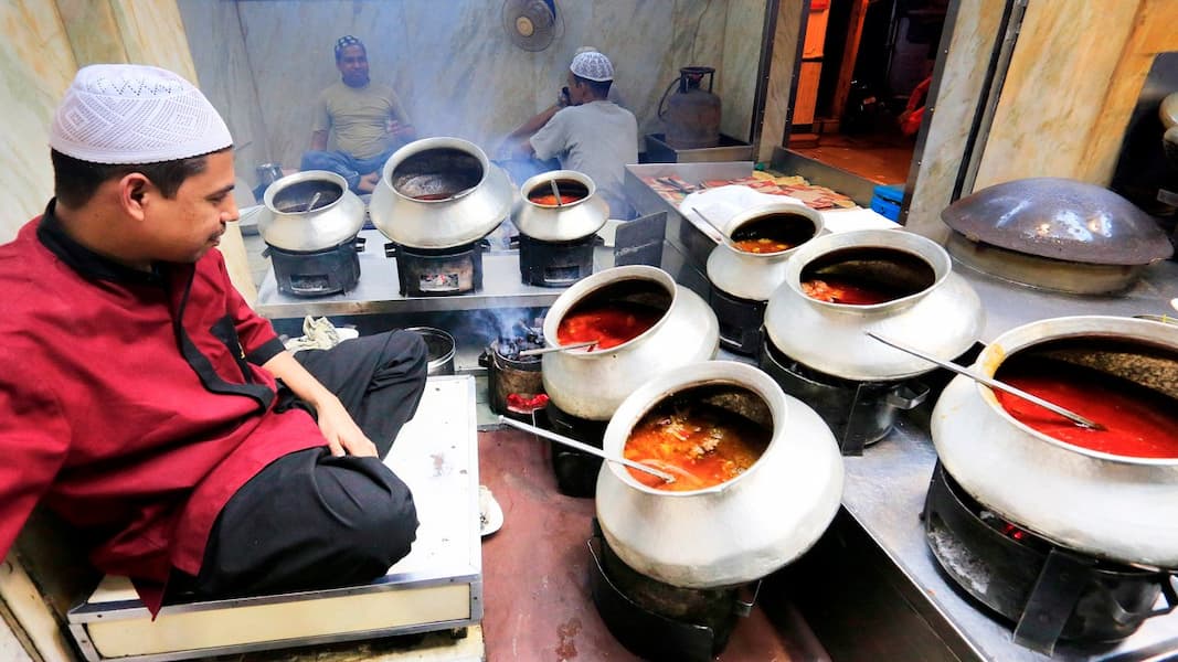 Muslim family enjoying halal Mughlai cuisine in Delhi, including biryani and kebabs