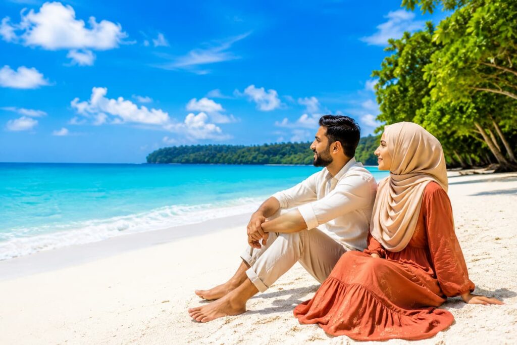 Muslim honeymoon couple relaxing on the white sands of Radhanagar Beach on an Andaman honeymoon trip