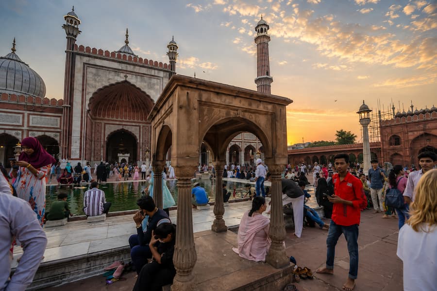 Muslim travelers in modest dress visiting the historic Jama Masjid (mosque) in Delhi