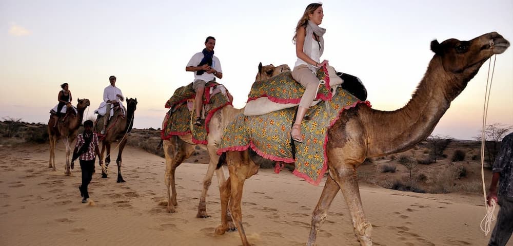 Muslim family enjoying a camel ride and desert safari at Jaisalmer's Sam Sand Dunes