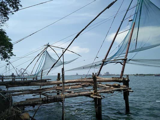 Muslim travelers exploring Fort Kochi's Chinese fishing nets on this 8-Day Kerala Halal Tour