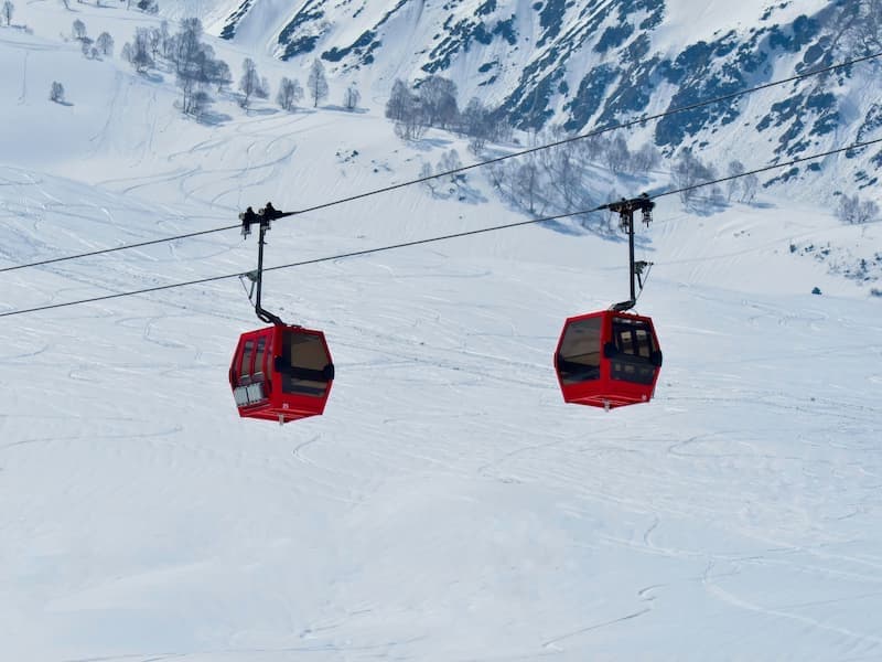 Muslim family riding the Gulmarg Gondola cable car over snow-covered pine forests