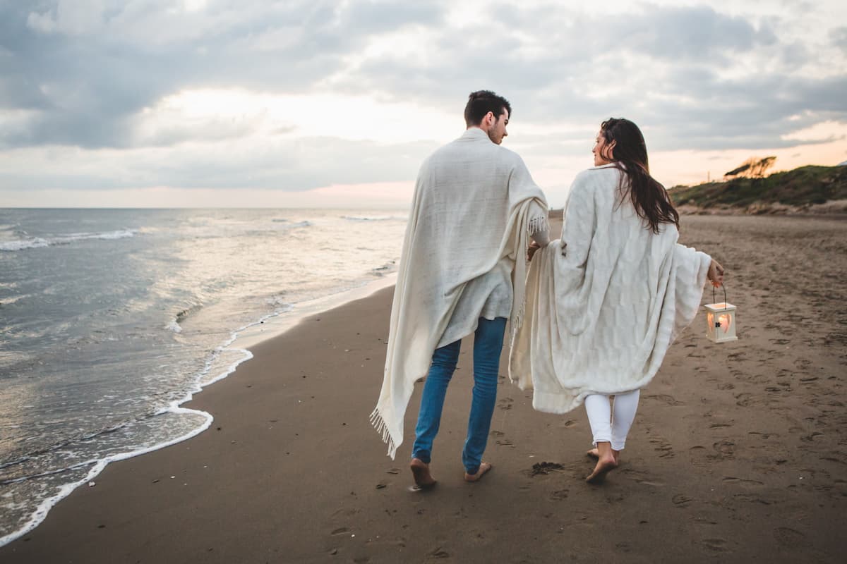 Muslim honeymoon couple enjoying a leisurely walk along the beach in Goa